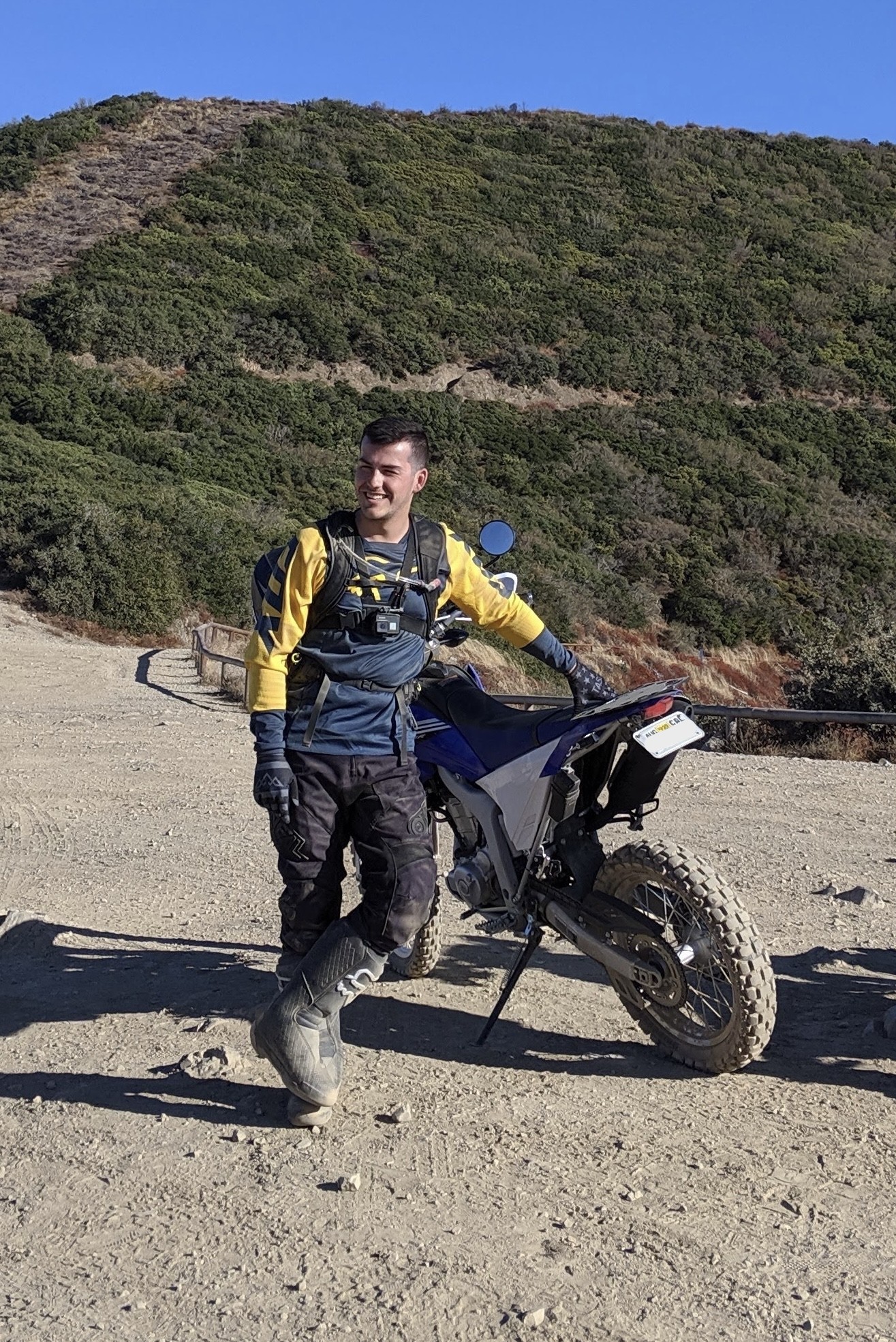 Man dressed in offroad moto gear posing with a dirtbike