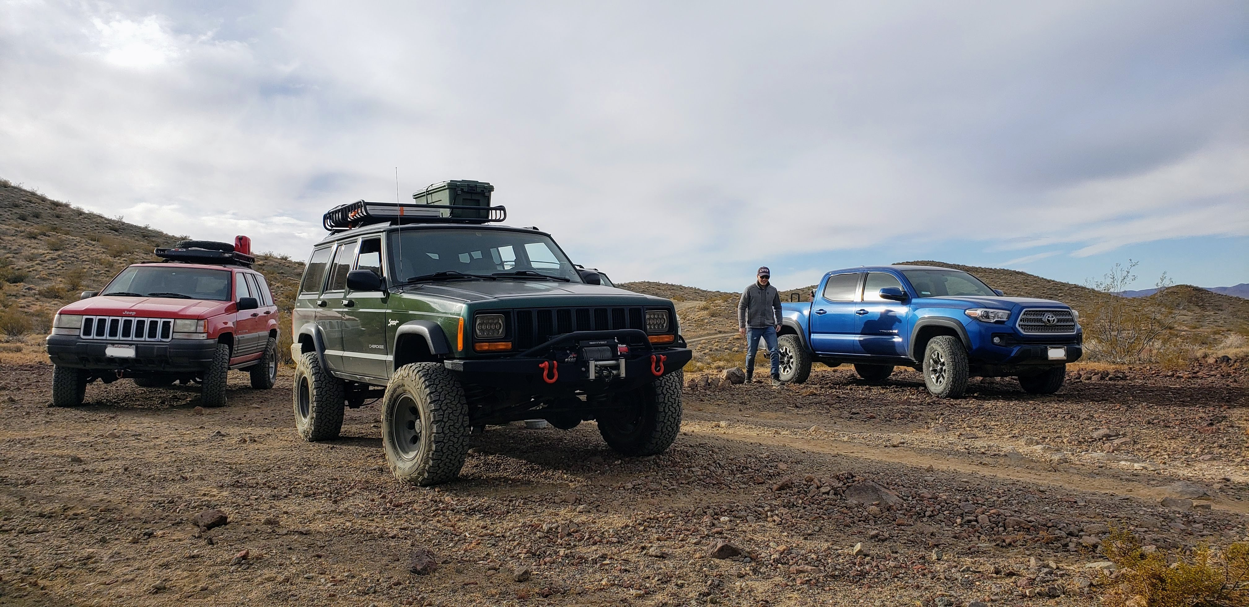 A red Jeep ZJ, a green Jeep XJ, and a blue 3rd gen Tacoma