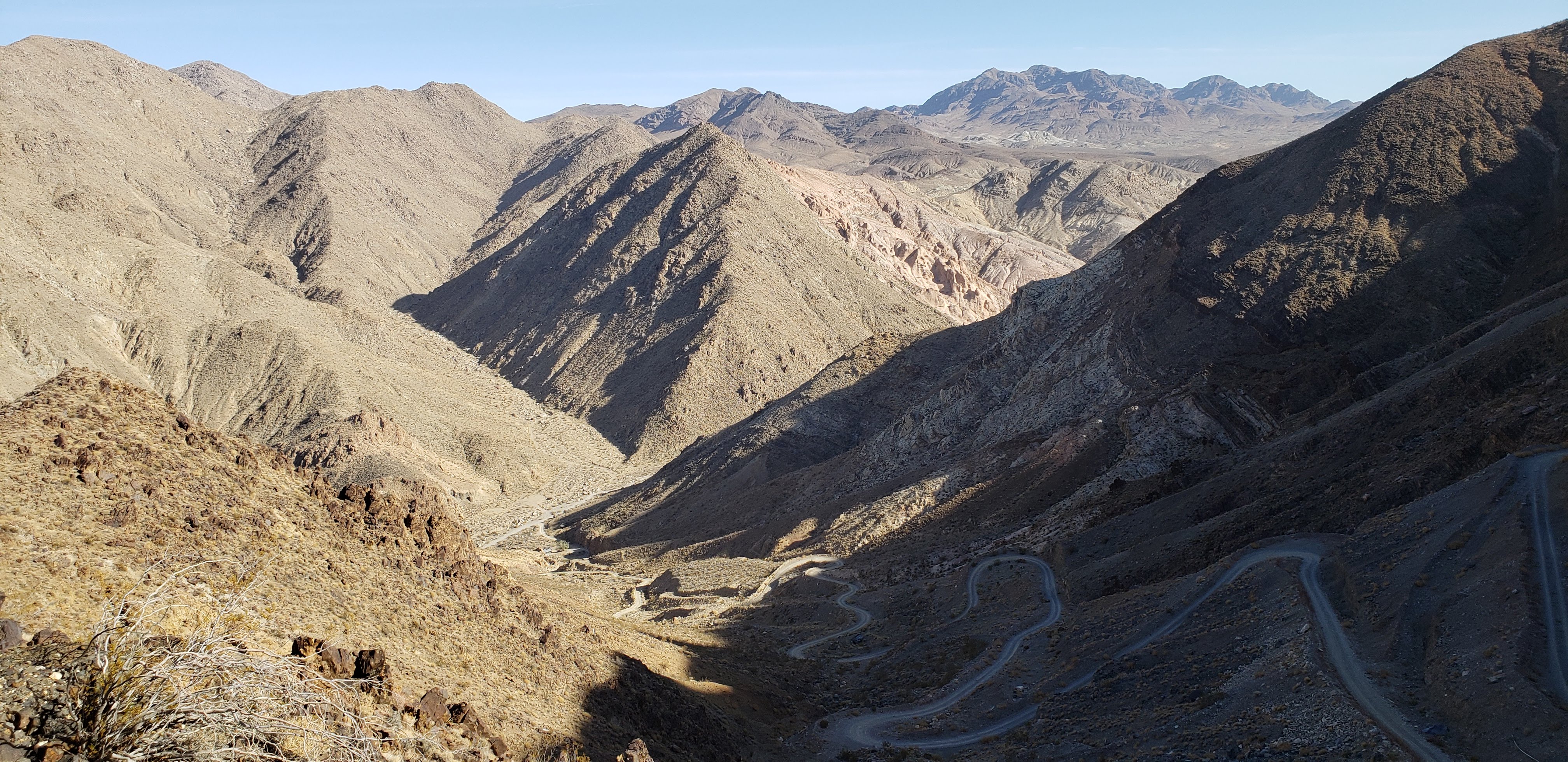 A windy dirt road down a steep canyon wall.