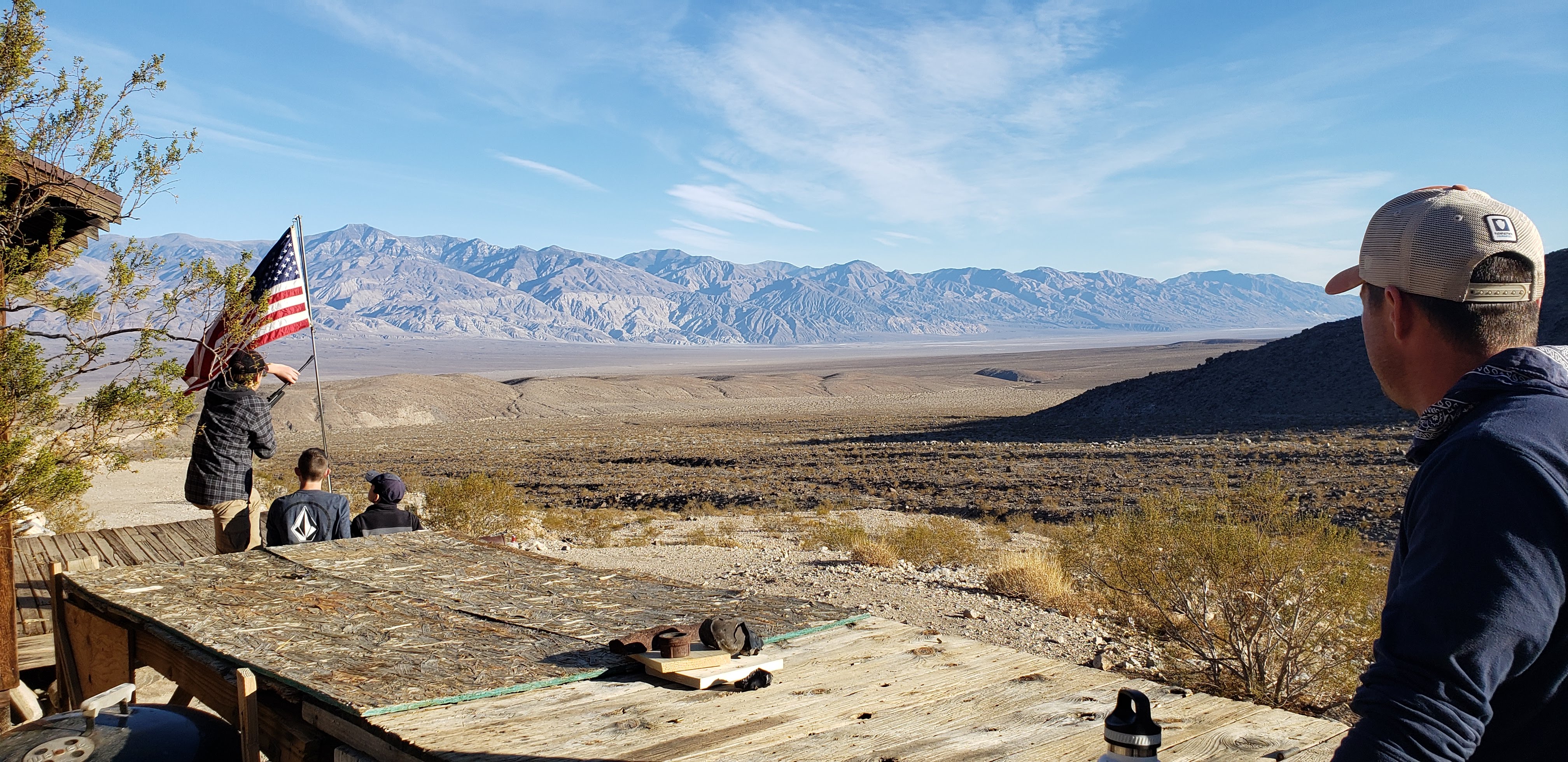 A wooden table in the foreground with an American flag and a vast expanse in the background.