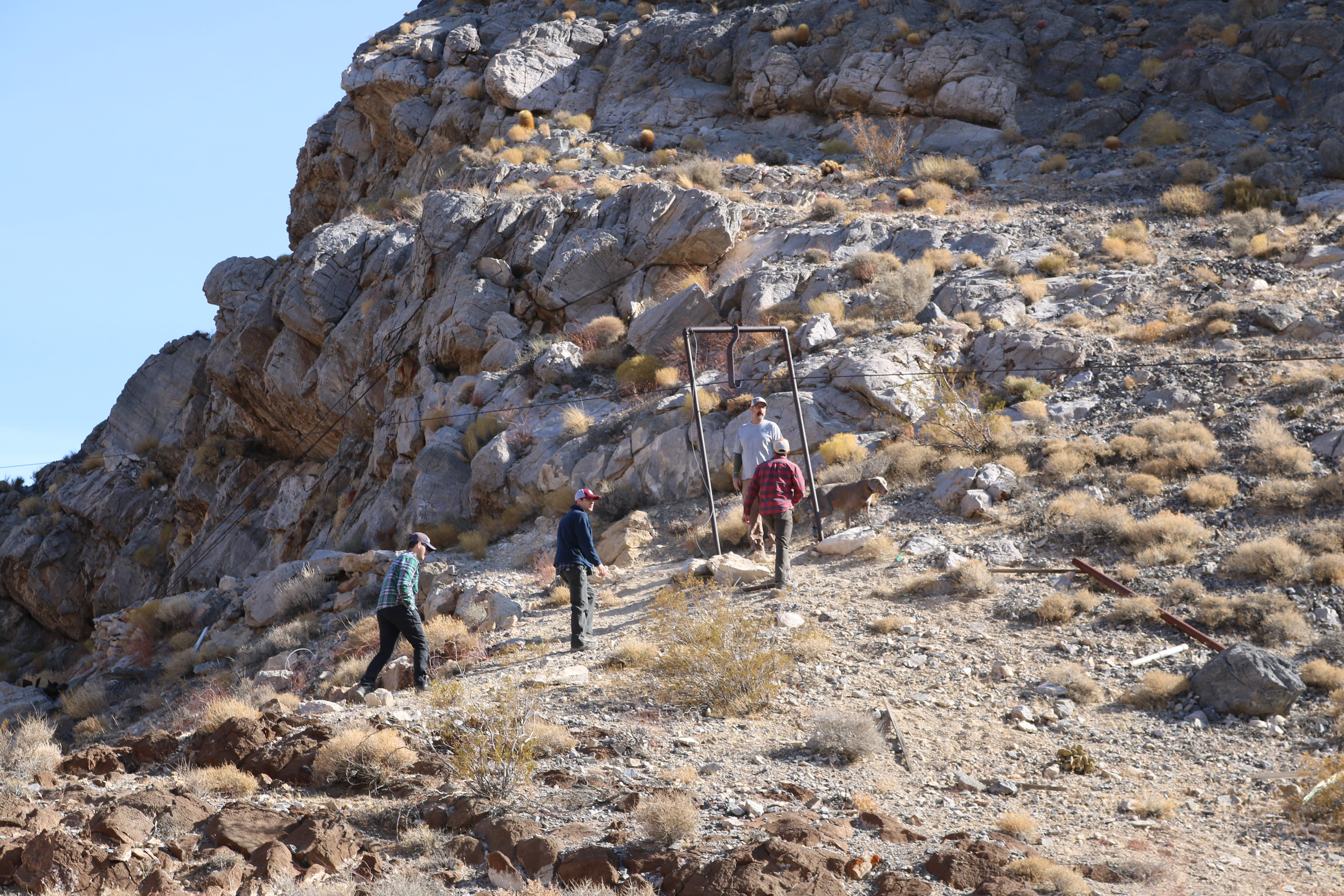 Men walking up a hill to look at artifacts from an old aerial tramway.