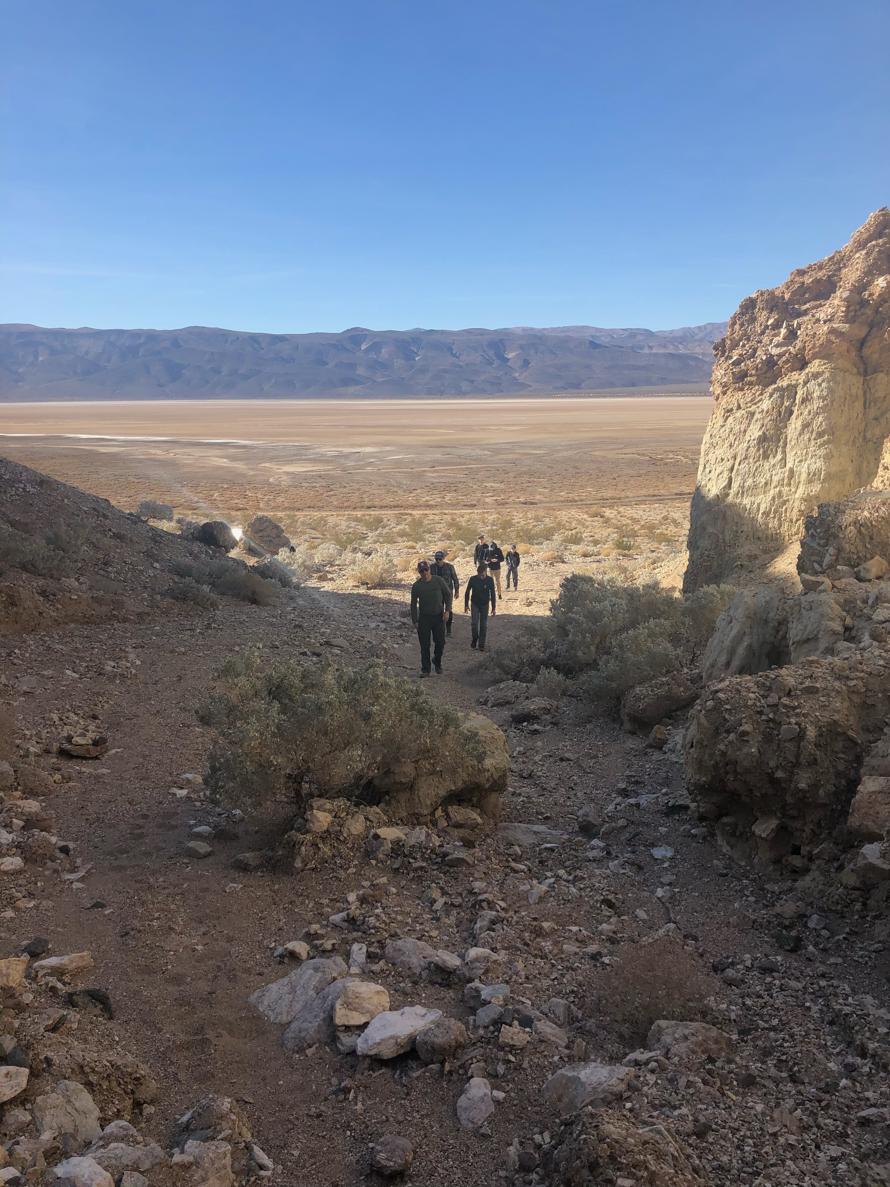 Boys entering a slot canyon from the flat valley.