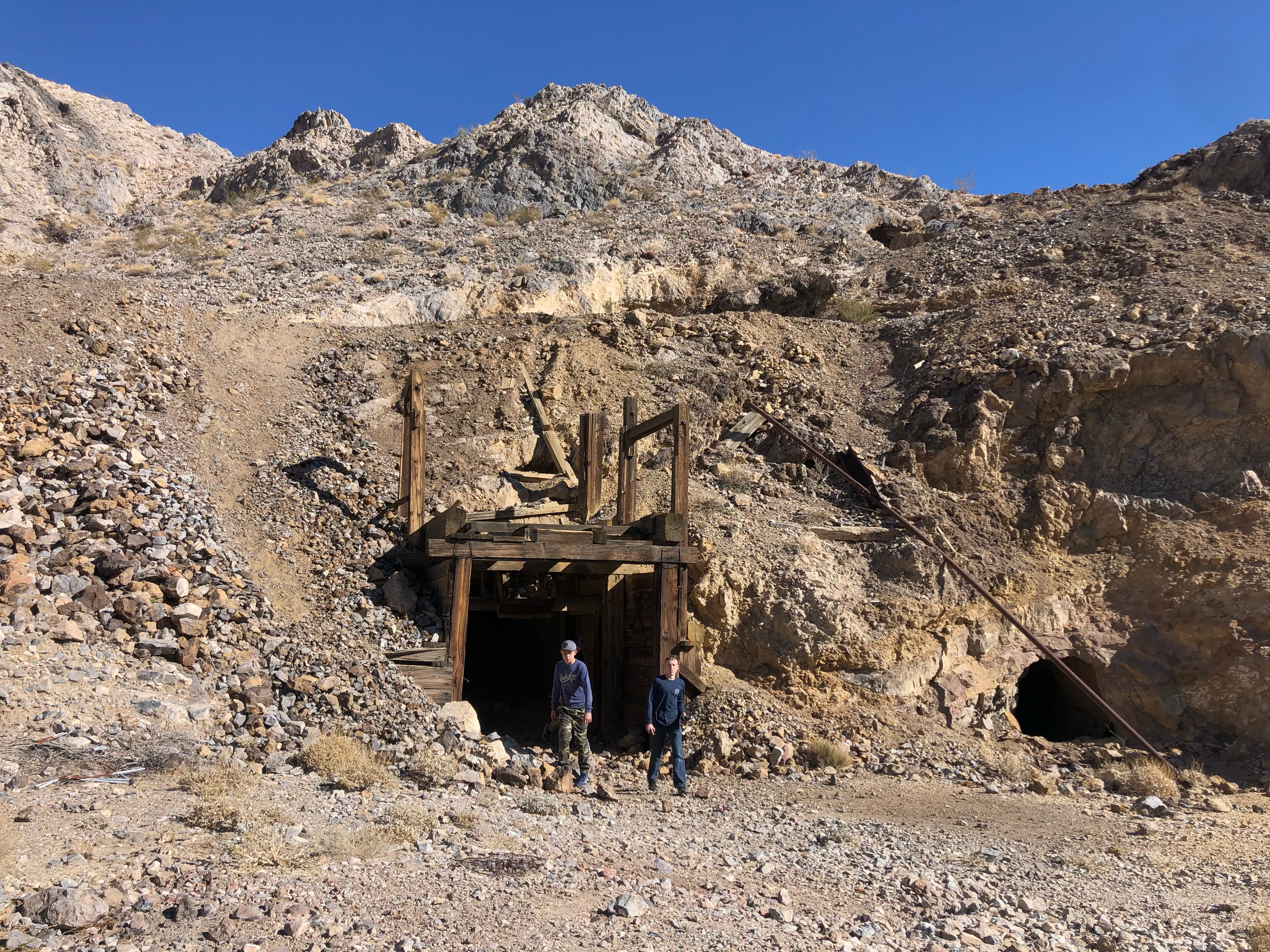 Two boys walking out of a mineshaft.