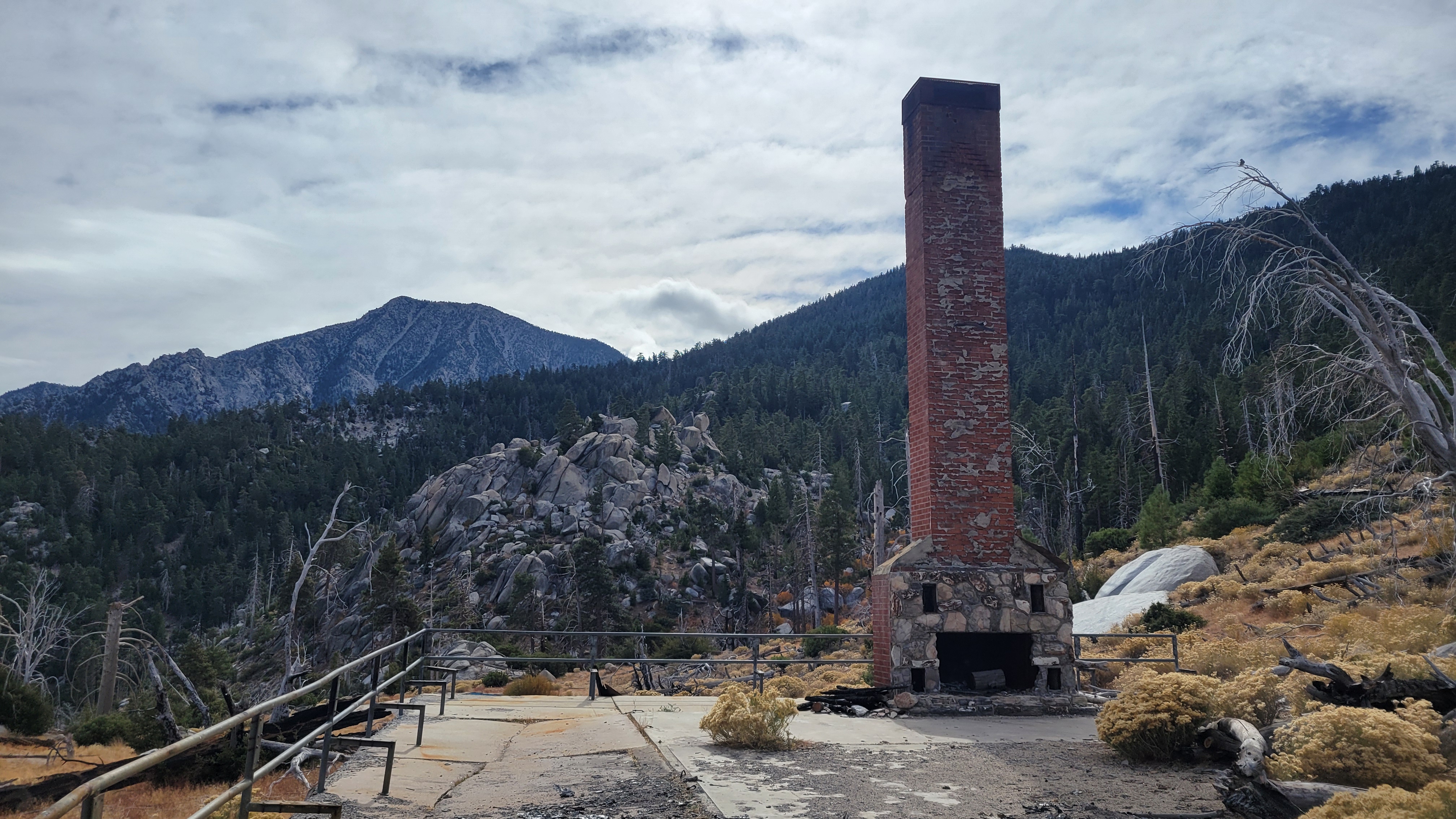 Mountainside landscape with a brick chimney standing oddly alone.