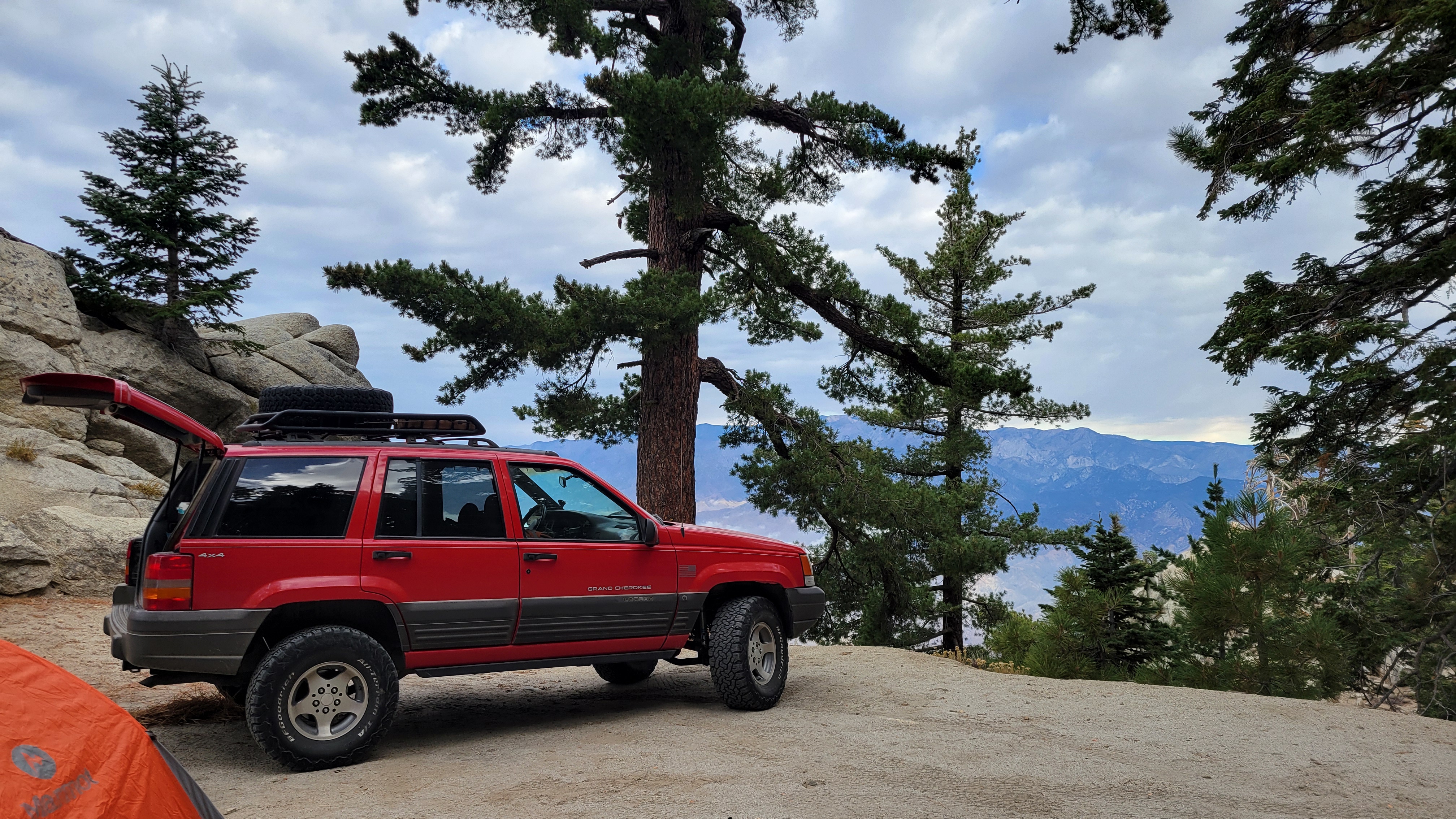 Red Jeep ZJ with a cliff-side view.